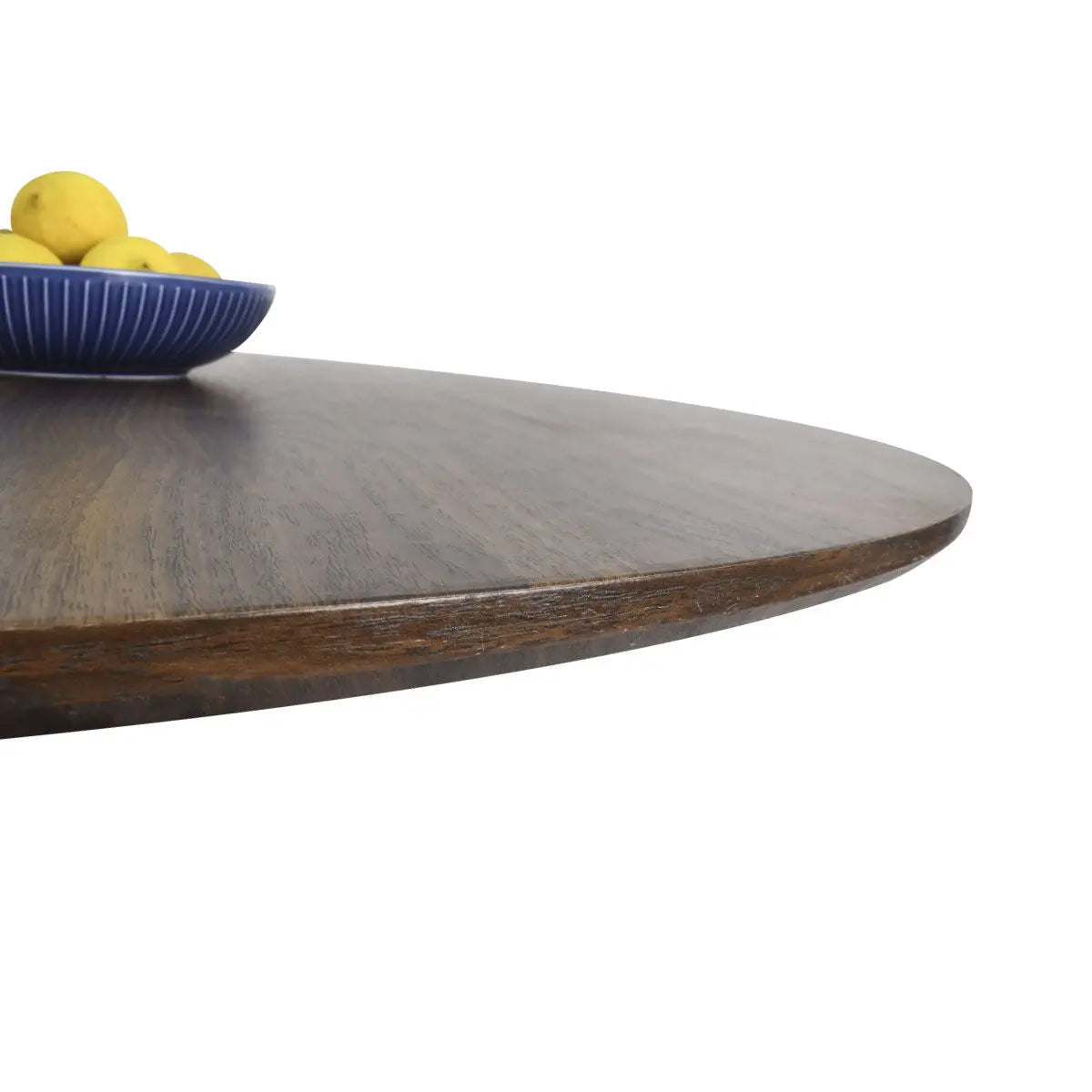 Close-up of Harold Modern Round Pedestal Dining Table edge with blue bowl and lemons.