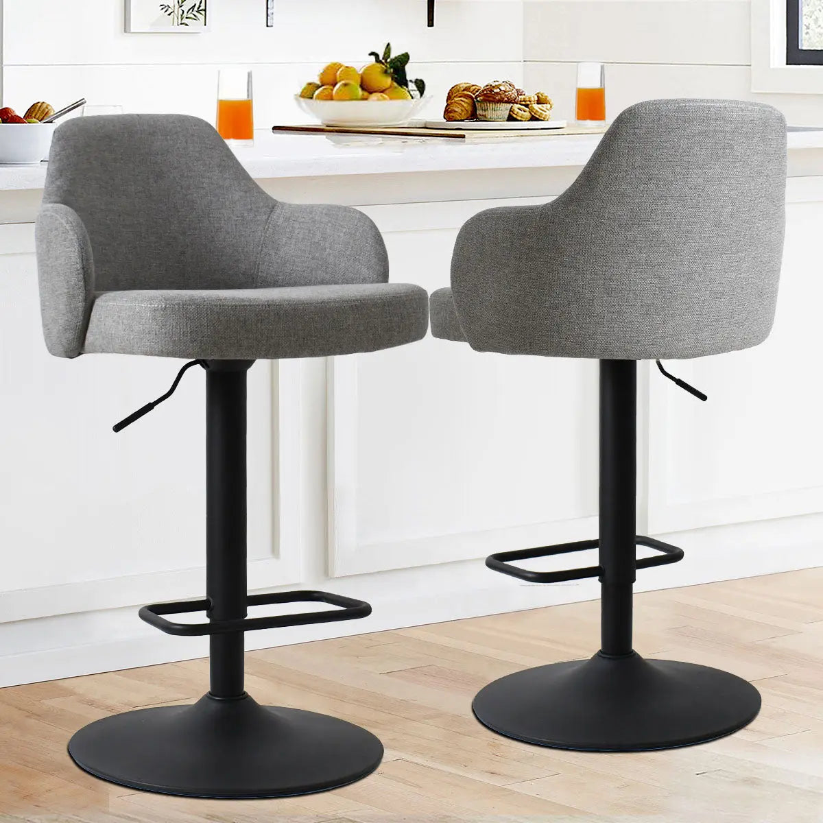 Gray Mars Upholstered Swivel Adjustable Stool with Arms, black base, light wood flooring kitchen setting.