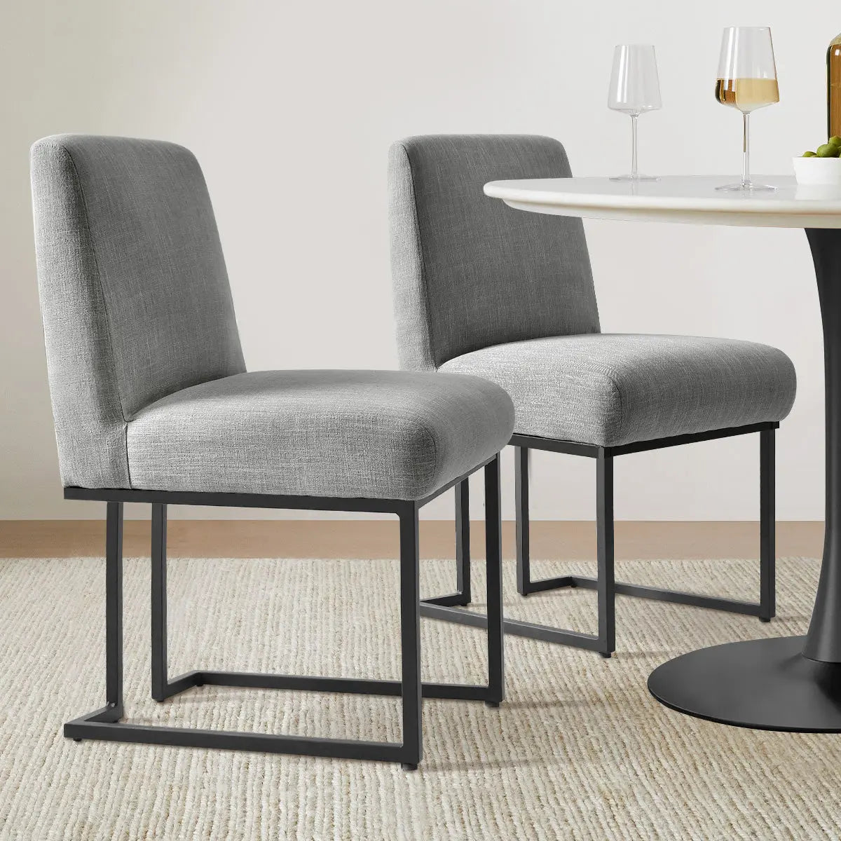 Mason Modern Metal Frame Upholstered Dining Chair, gray upholstery, round dining table, neutral carpet flooring.