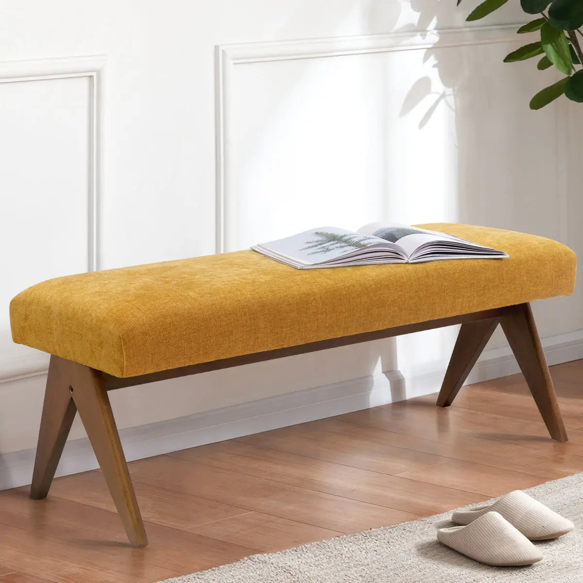 Morgan Mid-Century Upholstered Bench with mustard fabric, wooden legs, hardwood flooring, in a bright room.