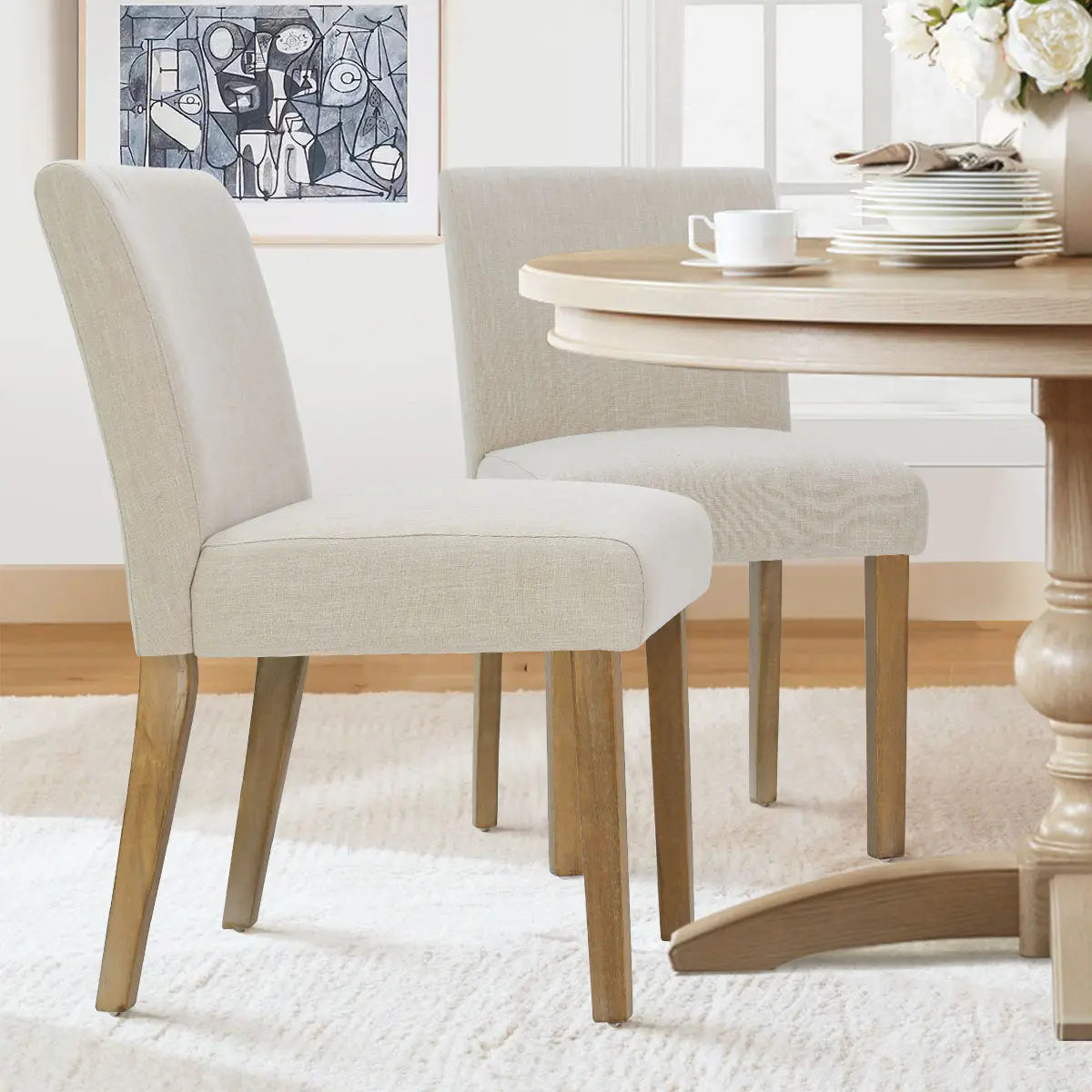 North Upholstered Dining Chair in a dining room with white rug and round wooden table.