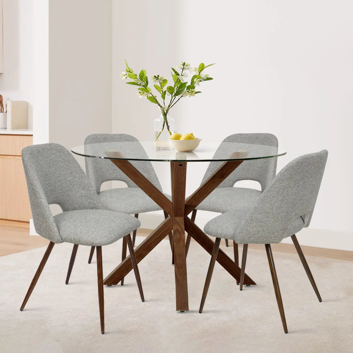 Oliver & Edwin dining set with round glass top, grey chairs, wood base, in cozy dining room.