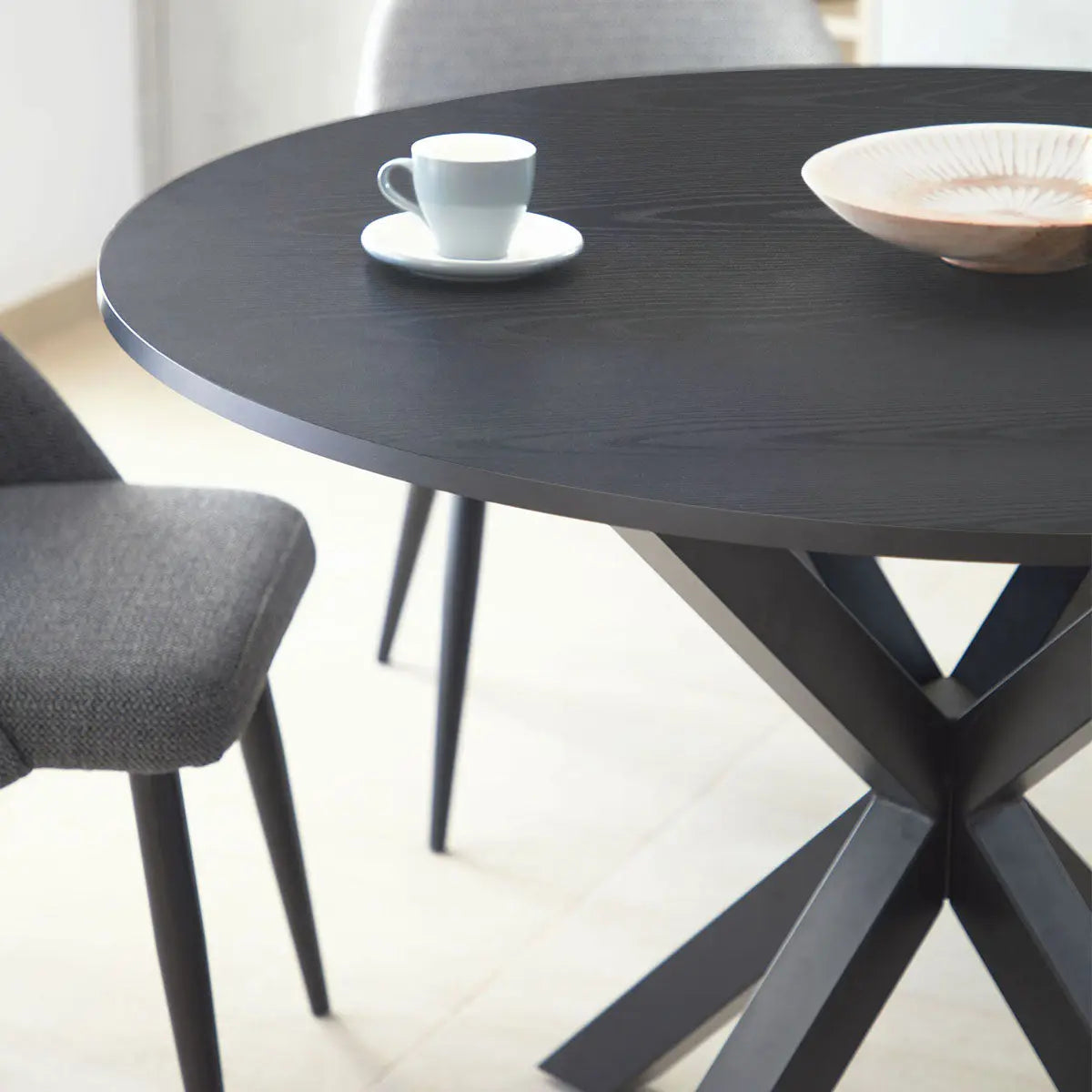 Oliver Modern Round Dining Table with gray chairs on light tile flooring in dining room setting.